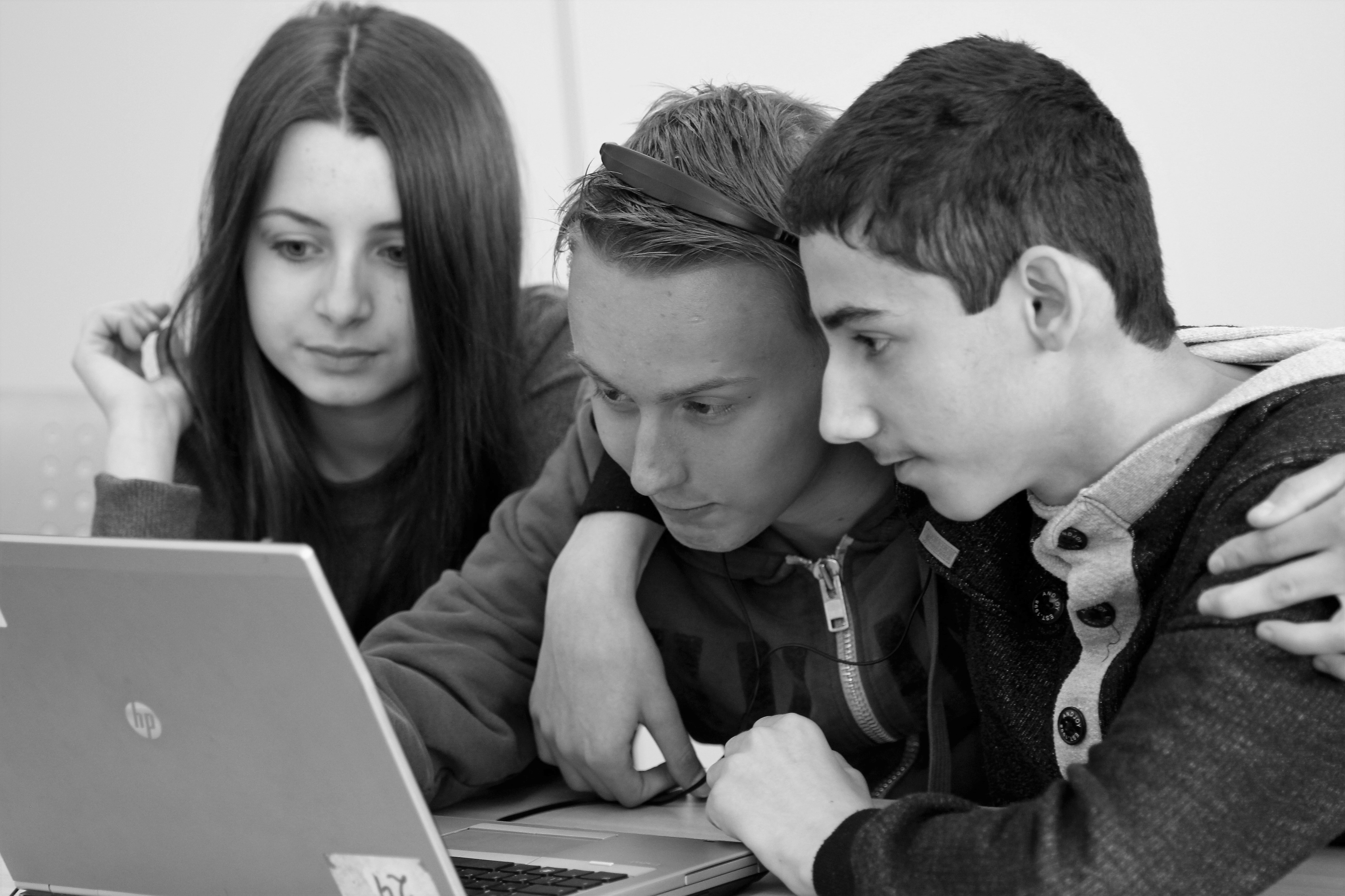 Tre elever ser på PC-skjerm