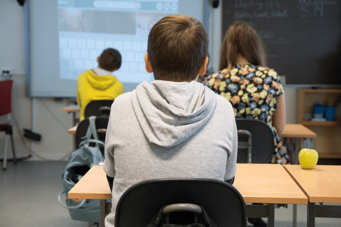 Gutt ser på tavlen i klasserom