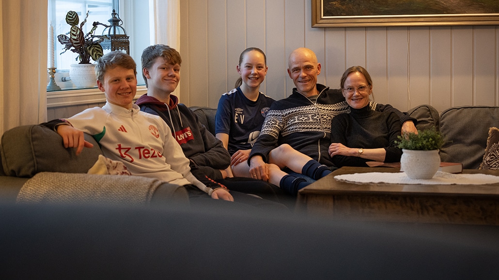 Foreldre og tre barn i sofa