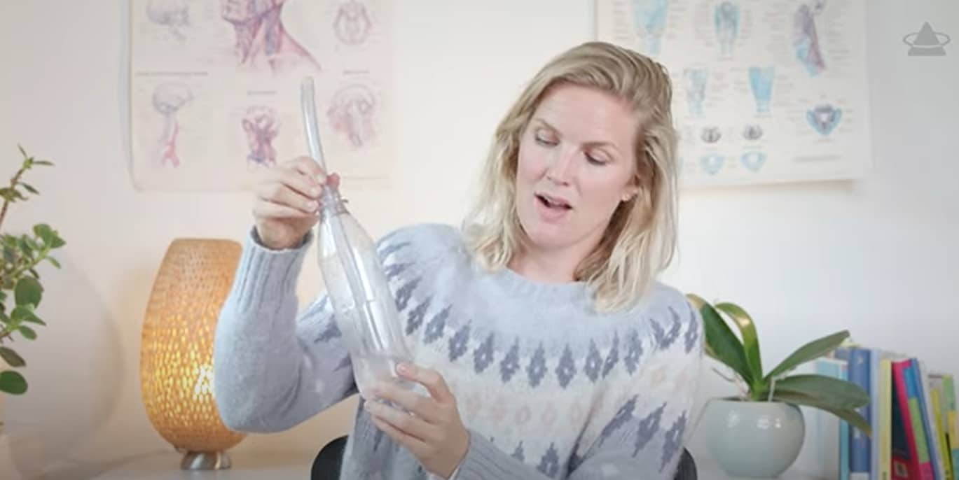 Viser en dame som holder en flaske og et rør