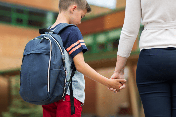 Gutt og mor står utenfor skolebygning