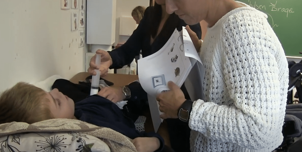 Voksen som viser tematavle til et barn