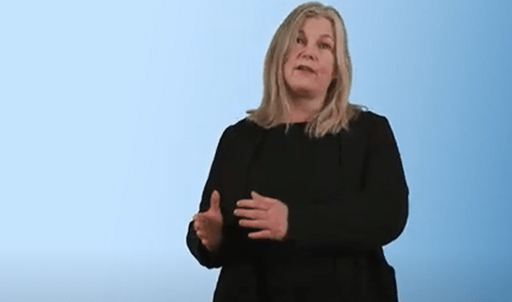 Skjermbilde fra en video, dame som forteller