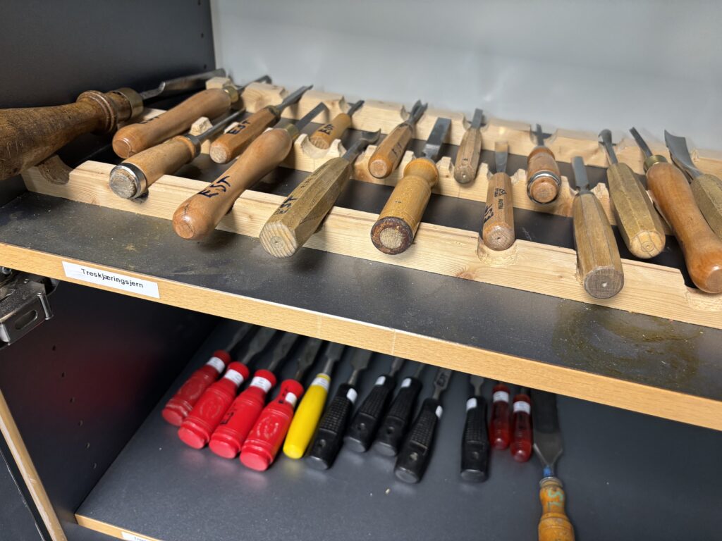 Verktøy på hyller, lagt tydelig på rekker og med markeringer.