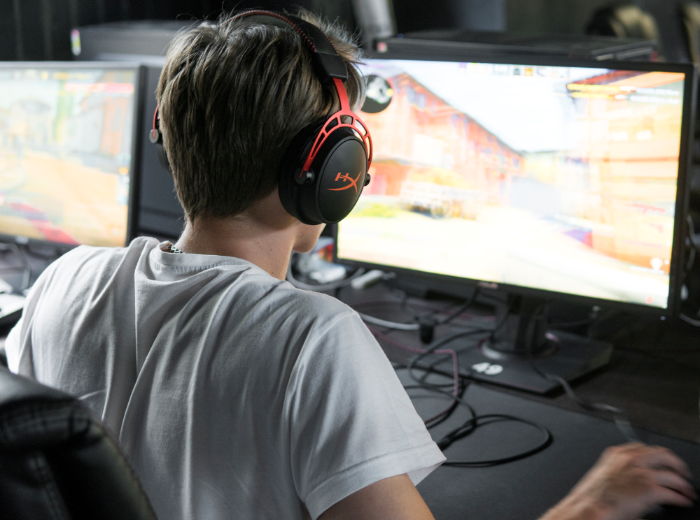 tenåringsgutt spiller på PC, sett bakfra