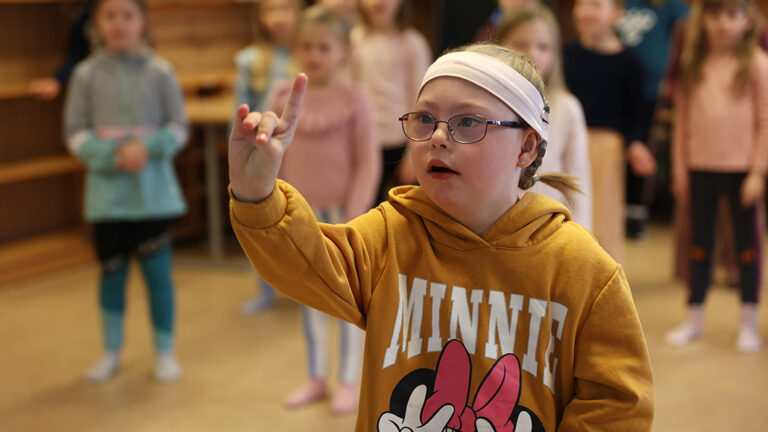 Pernille i musikktime der hun står på gulvet og danser med en finger i været