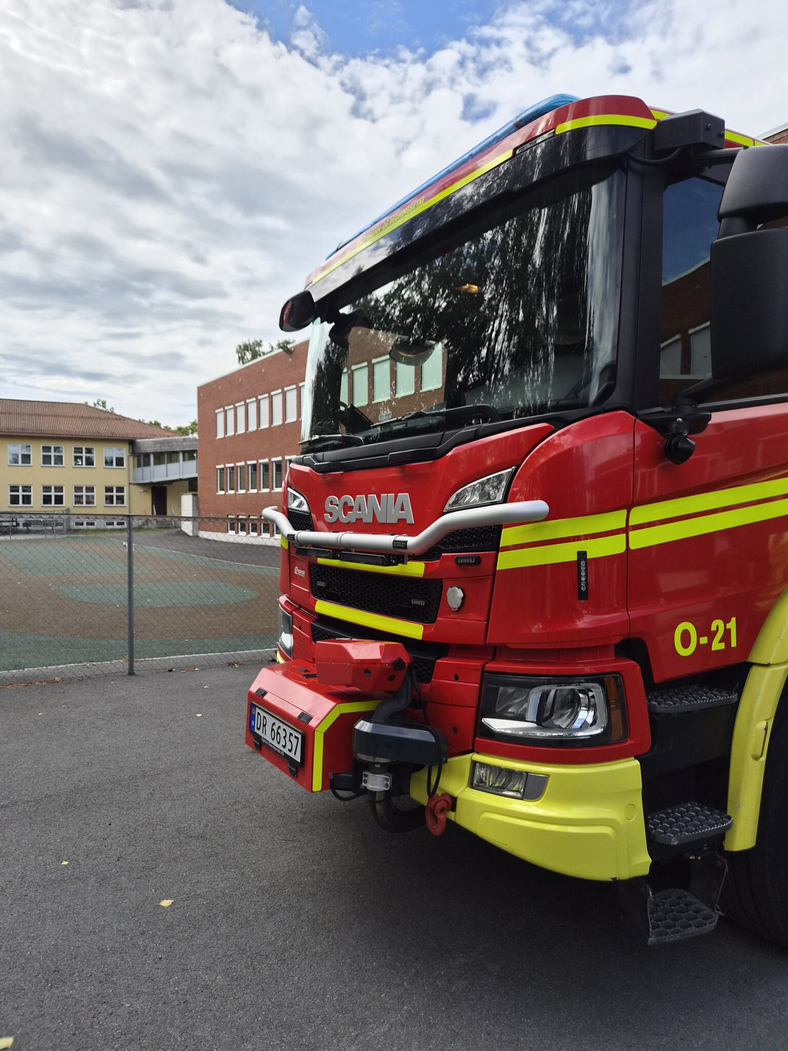 Rød og gul brannbil står parkert utenfor Diamanten skole