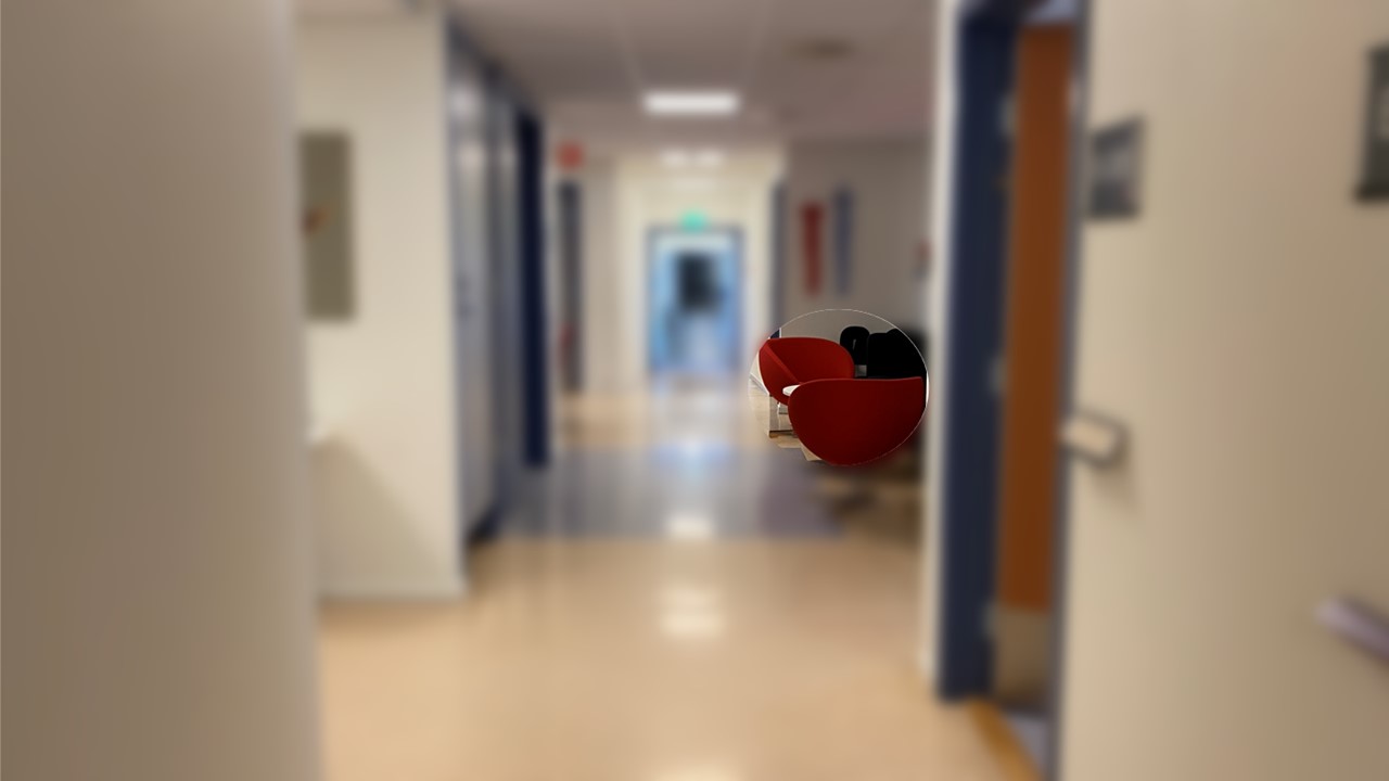 Korridor hvor to røde stoler er mer fremtredende enn korridoren rundt.