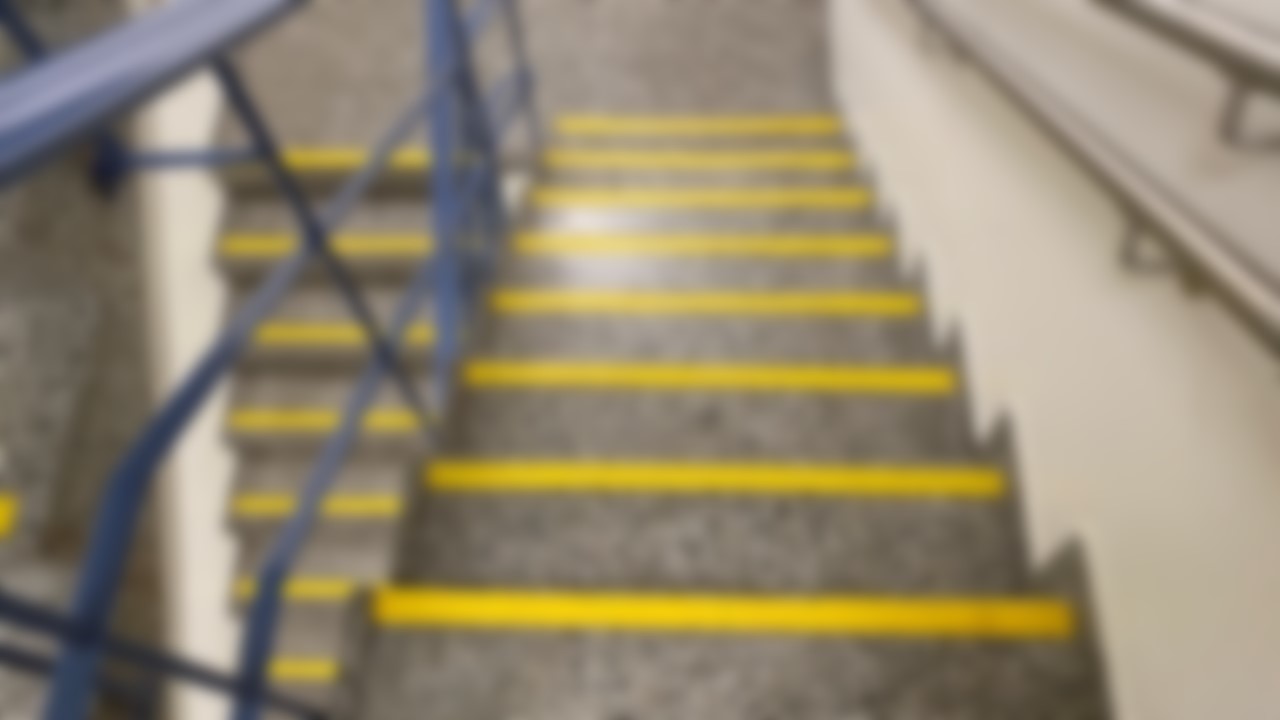 Grå trapp med tydelige gule trappeneser