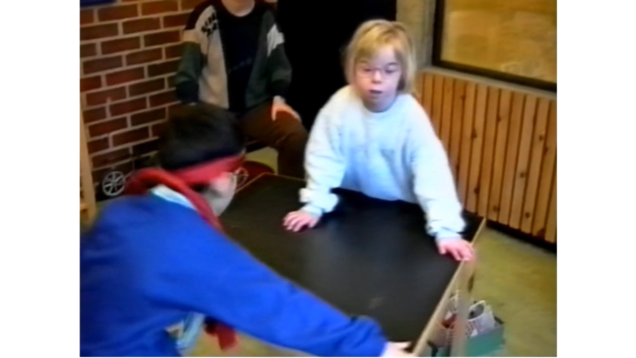Bilde av en jente og en gutt som dytter et bord.