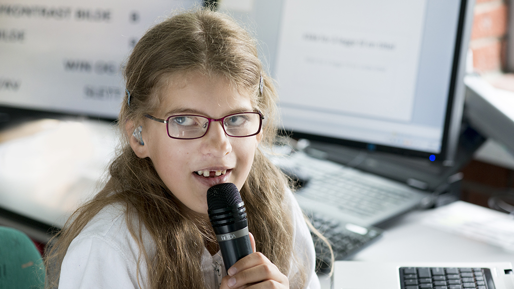 Foto av Anna fra 2014 da hun gikk på barneskolen. Her holder hun en mikrofon.