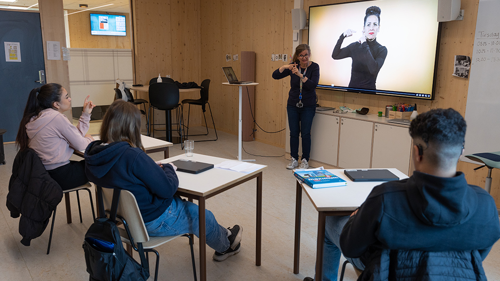 Bilde fra undervisningssituasjon med tegnspråklærere og tre elever