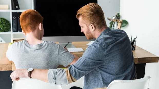  Foto: To personer sitter ved en skjerm og jobber med lekser